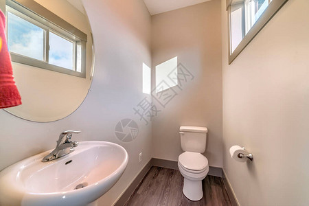 带有独立水槽圆形镜子厕所和木地板的家庭浴室图片