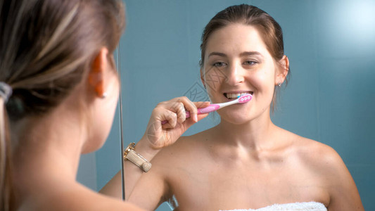 清晨微笑的年轻女子在浴室刷牙的肖像图片