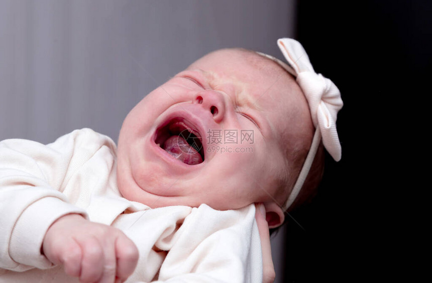 一个月大的女婴在母亲的怀里尖叫和哭泣图片