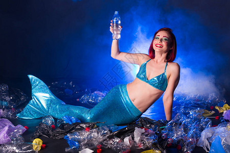 深海中奇幻的愚蠢的美人鱼塑料水瓶和袋对海底的污图片