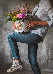 时尚女式牛仔裤衬衫专业花店持有组合野花盆店背景图片