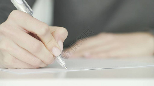 女人用钢笔写字的特写照片图片