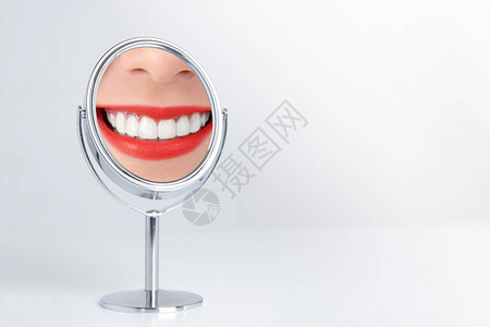洁白的牙齿干净而美丽红色的嘴唇反射在镜子上图片