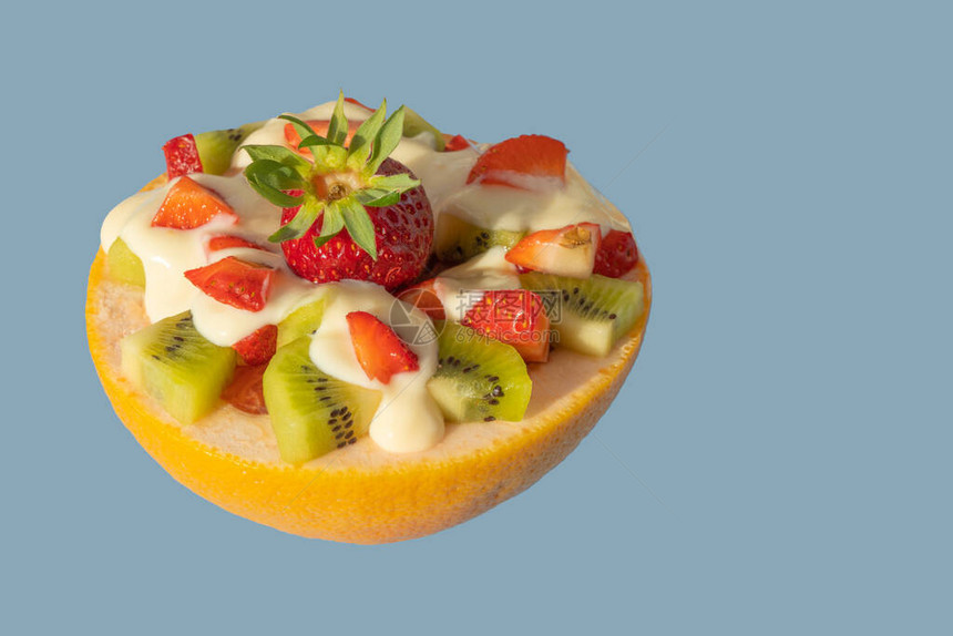 用葡萄柚做的锅里的水果沙拉蓝色背景上的水果食品健康和饮食早餐图片