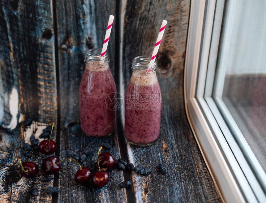 用纸管装在玻璃瓶子里的新鲜夏季浆果自制清凉水用樱桃蓝莓和牛奶制成的紫色饮料健康饮图片