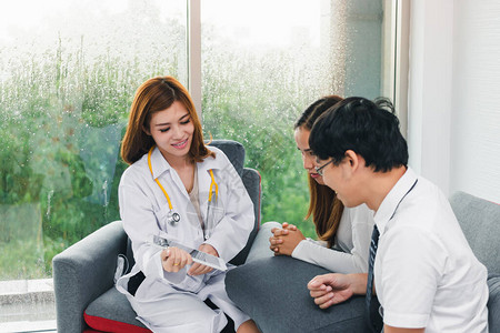 年轻的亚洲男医生在医院办公室咨询病人图片