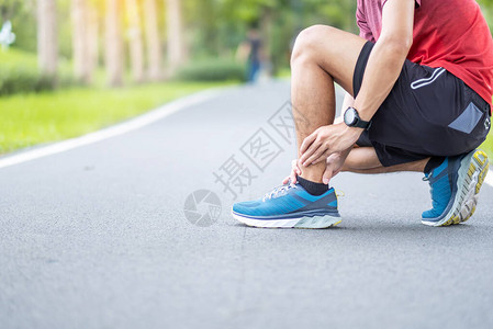 年轻的成年男在跑步时肌肉疼痛跑步者因脚踝扭伤或跟腱炎而腿痛运动损背景图片