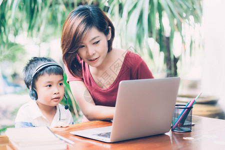 年轻的亚洲母子使用笔记本电脑在家一起学习和学习图片