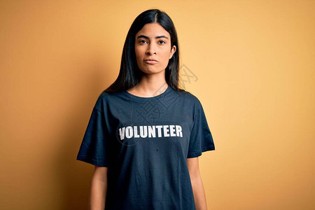 身穿志愿T恤的年轻美丽的西班牙裔女在社会慈善道德上放松图片