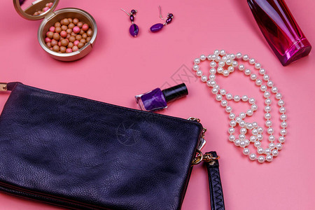 圆筒袋珍珠项链耳环指甲油红球和粉红色背景的香水瓶美图片