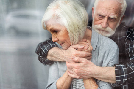 心烦意乱的老年男人抱着妻子患有痴呆症图片