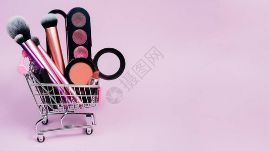 买家的粉红色手推车中的眼影腮红口红和各种化妆刷网上购物装饰化妆品的概图片