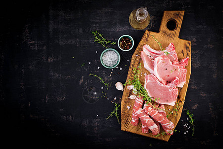 乌黑桌上有不同种类的生猪肉和切烤香肠顶端风景高背景图片