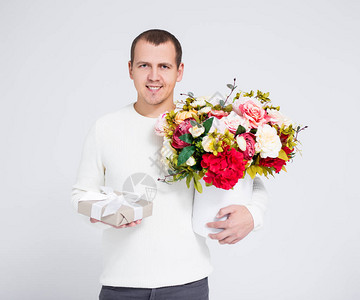情人节的情人节概念英俊男人拿着花束和礼物盒图片