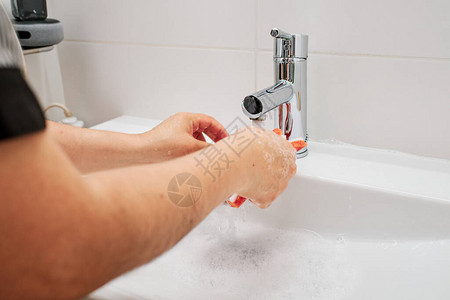 一个用手套清洁浴室水槽的人图片