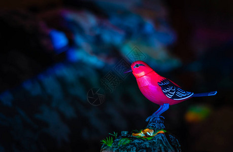 明亮的红色机械鸟在地球的形式的立场上图片