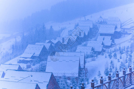 森林中温冬雪景的寒冷小镇风景背景图片