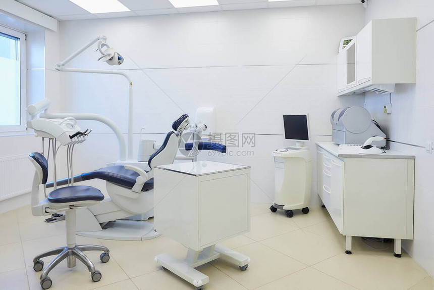 牙科诊所的内部配有白色和蓝色家具牙科椅湿磨和研磨机口内扫描仪led聚合灯牙医办公室图片