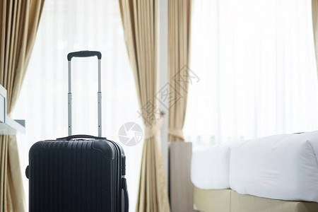 现代酒店客房内的黑色行李箱图片