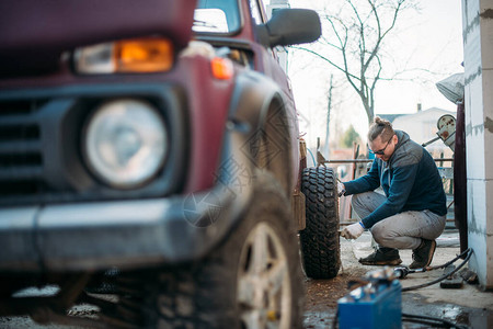 一个男人修车装轮子更换季节轮胎背景图片