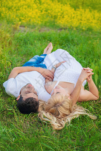 孕妇和男人的照片拍摄躺在草地上图片