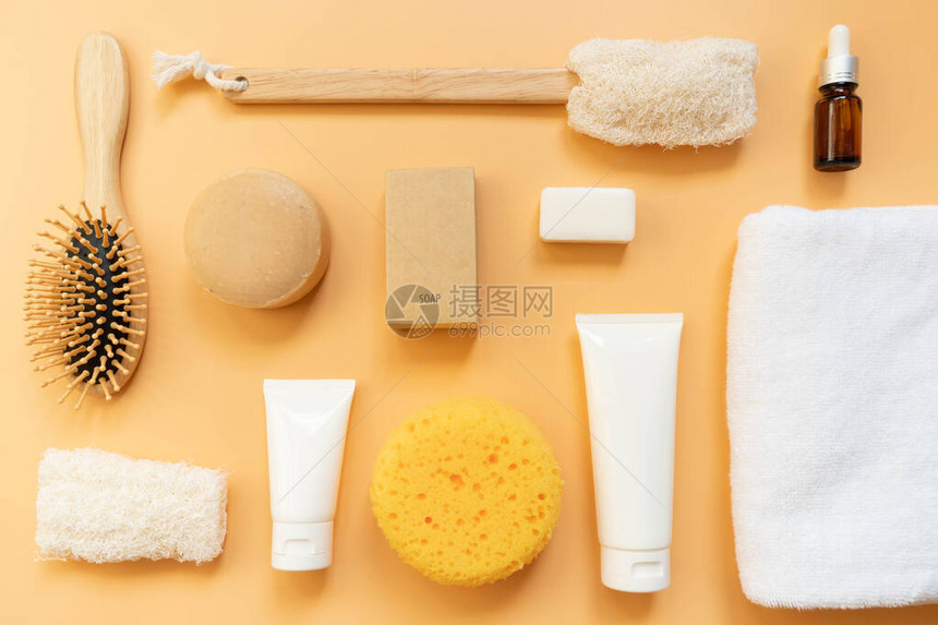 橙色背景上的一套沐浴产品肥皂条洗发水乳液面部泡沫精油毛巾海绵梳刷和丝瓜的顶视图芳香疗法和身体护图片