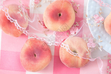 在桌布上撒开的浅粉红桃子甜图片