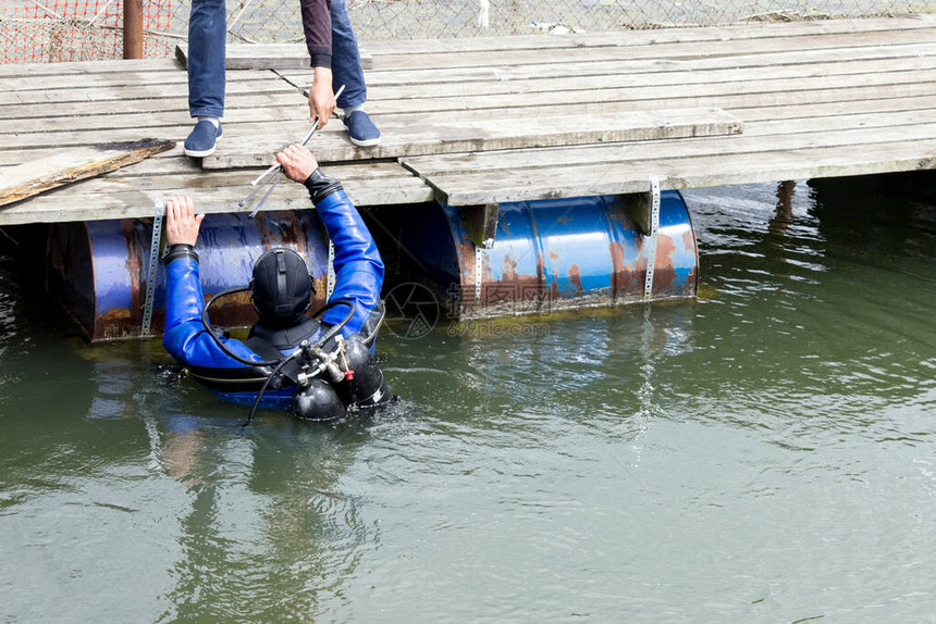穿着蓝色潜服的潜员在河里游泳并清理库中的碎片艰苦的危险工作假期概念世界环境日和世界日环图片