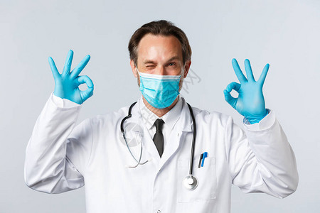 戴着医用口罩和手套的友好微笑医生图片