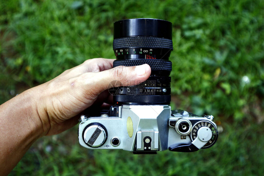 在户外公园拍摄老旧的单一镜头反射镜或SLR图片