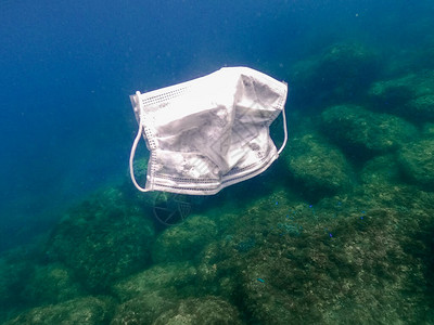 人们在海水中扔出医用口罩用过的外科口罩漂浮在海底无用的考拉卫生面具背景图片