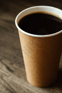 在咖啡店的木桌上放着黑色现煮咖啡的纸杯在糖果店喝热咖啡或在酒吧酒吧图片