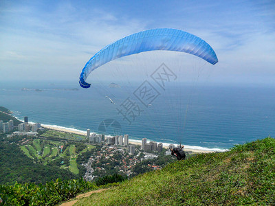 男子滑翔伞在巴西里约热内卢美丽岩石图片