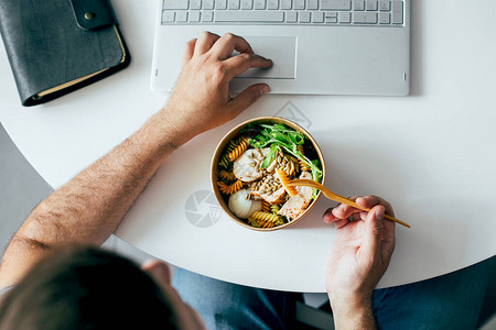 在男人的手中吃健康的午餐碗办公室送餐节食排毒素食图片