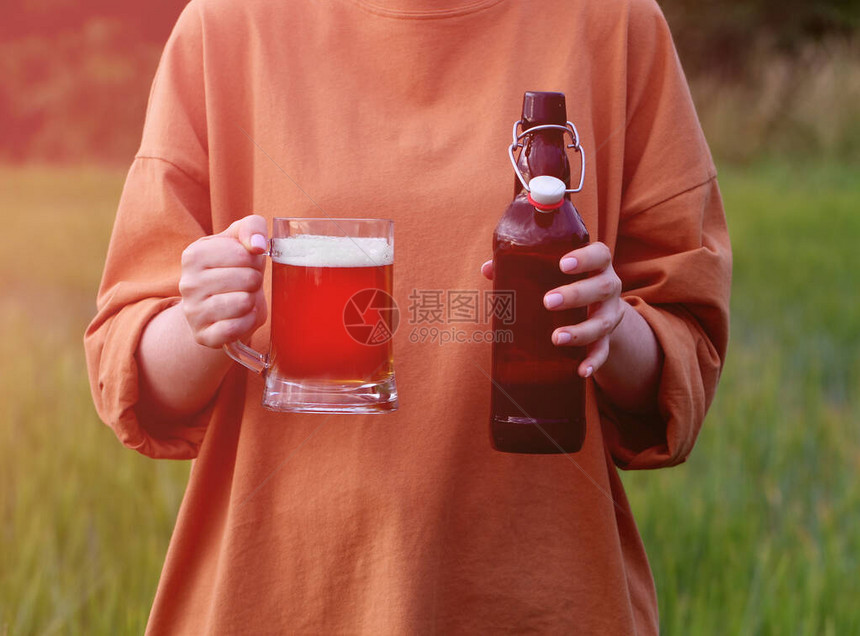 用一杯深色精酿啤酒和一个深色玻璃啤酒瓶与户外喇叭塞特写女手BrewingOktoberfest图片