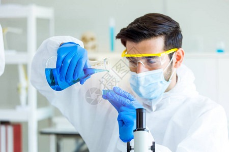 一位医学科家正在实验室内研究和试验有效的生物化学物质和反应图片