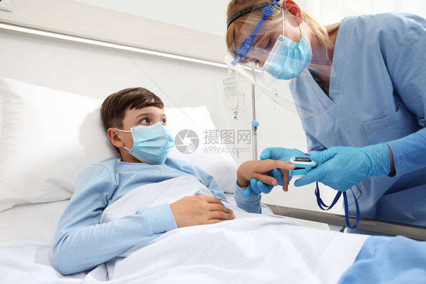 护士在病床上给病人的孩子带脉搏血氧仪图片