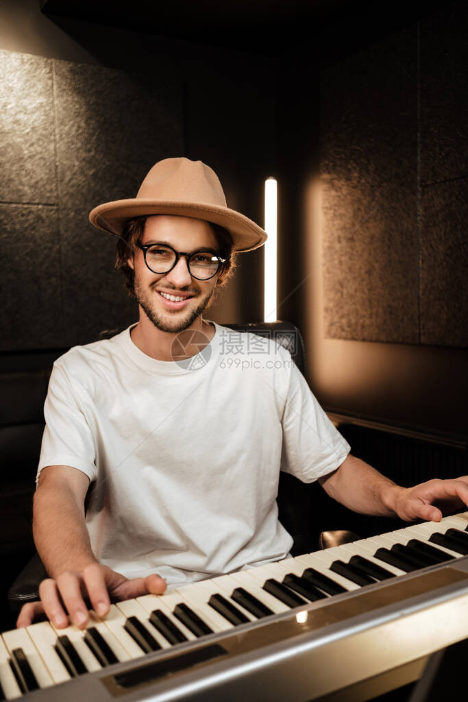 年轻时尚的音乐编曲者在录音室用midi钢琴创作歌曲有魅力的家伙在工作室里愉快图片