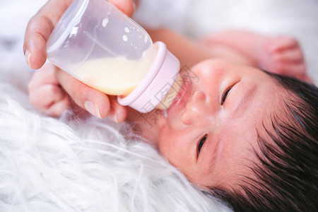 婴儿正在用奶瓶喝奶妈正在母乳喂养图片