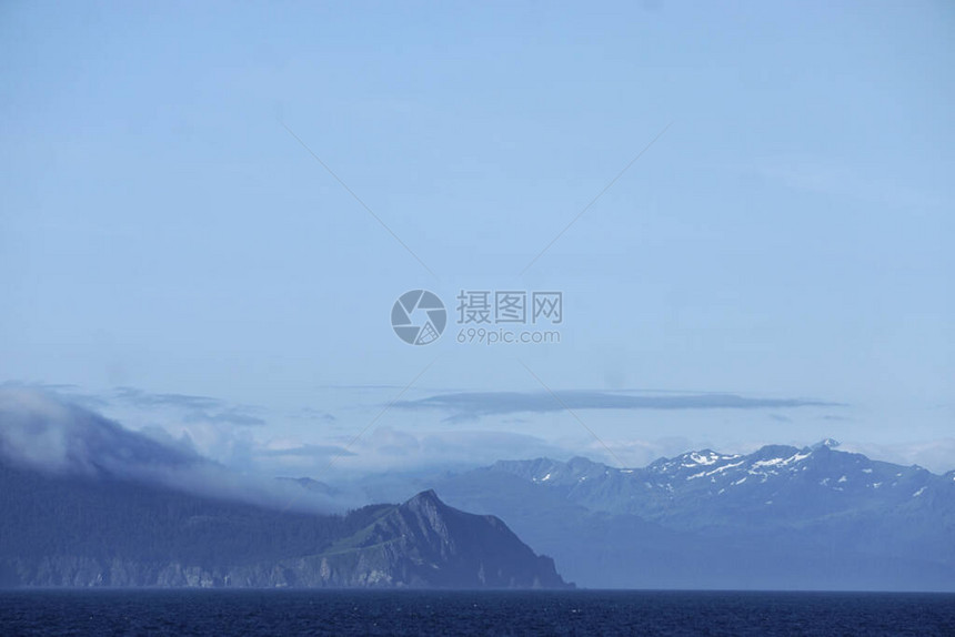 从阿拉斯加湾的一艘游轮上看到群岛和遥远的雪峰高山图片