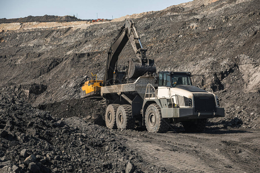 大型采石场自卸车将岩石装入自卸车将煤炭装载到车身卡车中生产有用的矿物采矿卡车采矿机械图片