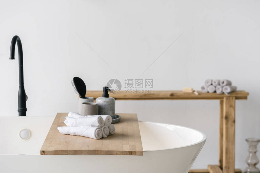 发刷皂液器和干净的干净毛巾放在木架子上图片