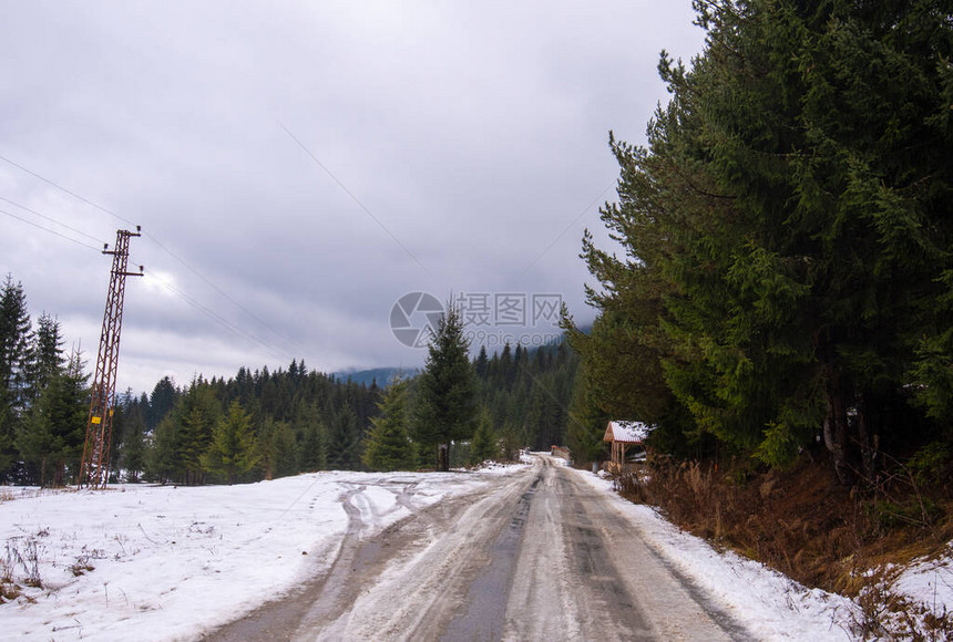 一条新鲜的绿色松树林和覆盖着雪的摩托车路在冬天拍摄来自保加利亚的山景圣诞图片