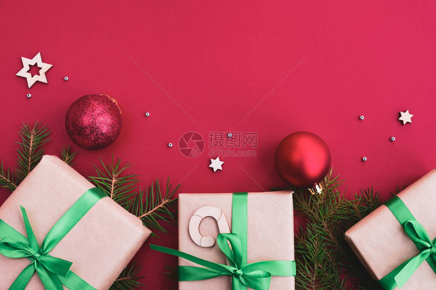 圣诞节和新年作文礼物圣诞球枞树红色明亮背景上的节日装饰顶视图平图片
