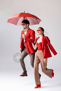 红衣和墨镜中时装情侣的全长视光带着灰色图片