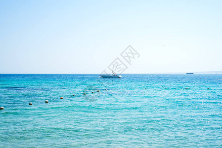 海洋风景有石质海岸线冲浪板冠和停泊船只蓝海水上的船图片