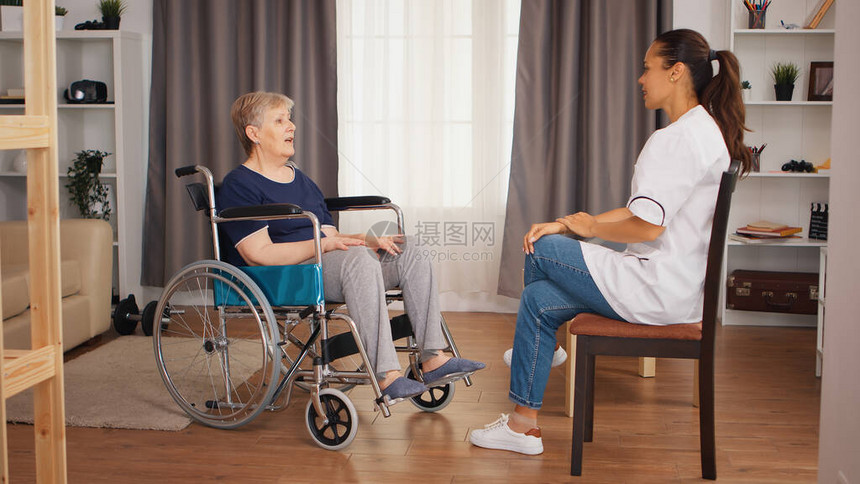 坐在轮椅上的残疾高级妇女与护士交谈老人养老院保健护理健康支持社会救助医图片