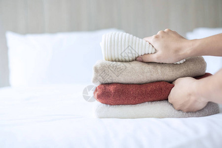 在豪华酒店度假胜地或家中的床上搭配蜜蜂羊毛滑雪者放松秋天或冬衣洗图片