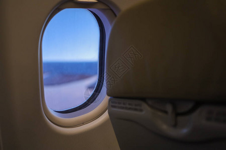 近距离接近奥瓦尔飞机窗口和经济舱后方的蓝色天空图片