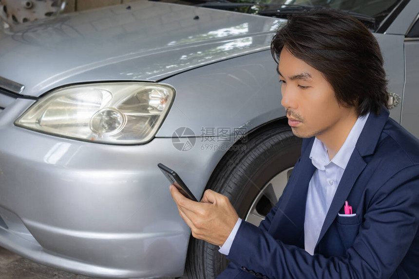 亚洲保险代理人或保险代理人在SuitTouch智能手机和检查车祸事故中的图片